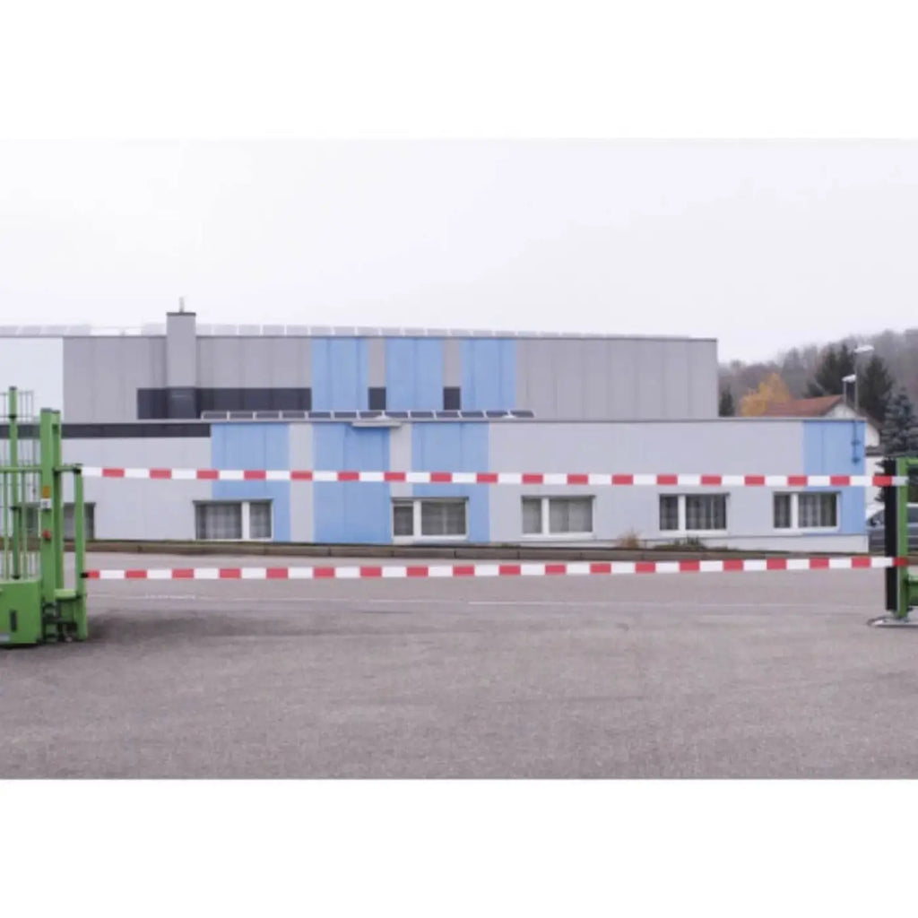 Absperrband 80mm x 500m mit rot-weiß gestreiftem absperrarm vor gebäude auf gepflasterter fläche