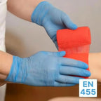 Gloved hands applying bright red textured elastic bandage with arnomed nitril-handschuhe puderfrei 200 stück