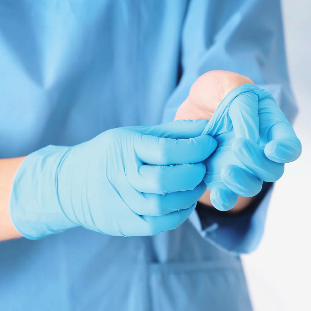 Person zieht Hygonorm "Safe Fit" Nitril-Handschuhe Blau 100 Stück von Franz Mensch an, hygienisch und schützend.