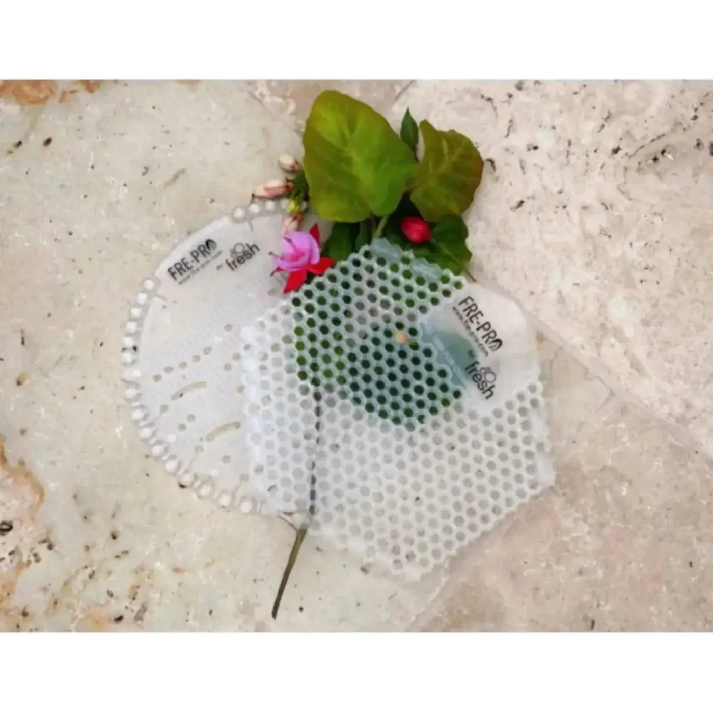 Weiße perforierte plastik-pflanzenvermehrungstabletts mit free-pro und fresh branding, eine mit grünen blättern und pinken blumen, frepro wave 3d urinaleinlage urinalsieb mit duft