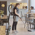 Grauer nilfisk gd5 back hepa basic rucksackstaubsauger mit schwarzem schlauch und griff von hinten gesehen