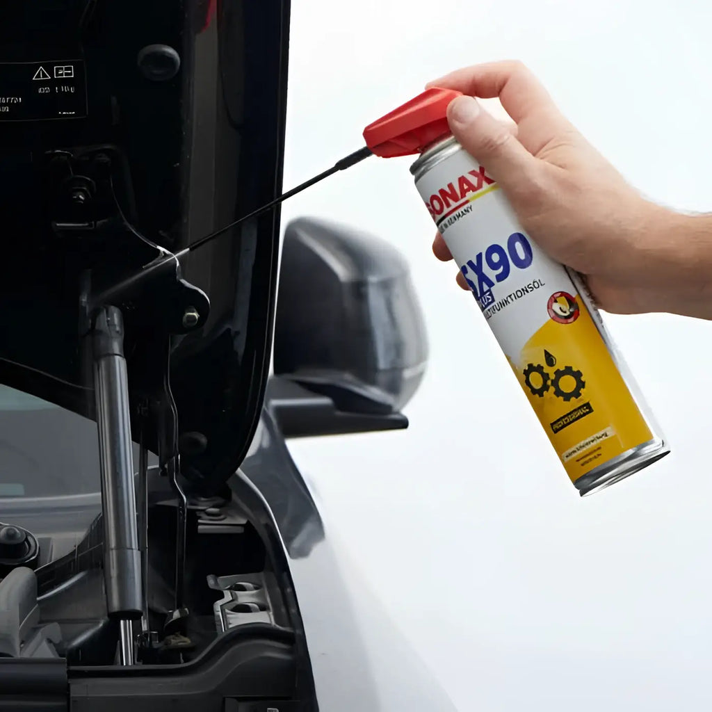 Eine hand hält eine rot-weiße dose sonax professional sx90 plus easyspray multifunktionsöl mit langem schwarzen auftragsdüse für fahrzeugschmierung