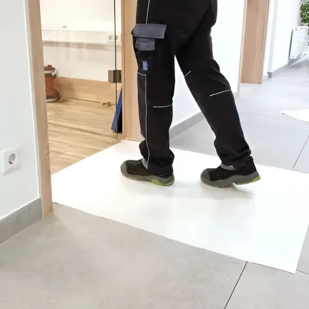 Schwarze cargohose mit grauen taschen und weißen nähte auf einer Staubstopp-Matte 1150 mm x 650 mm stehend