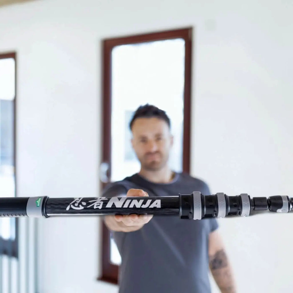 Schwarzer und silberner ausziehbarer carbon-moppstiel mit ninja branding für das unger ninja 6in1 glasreinigungsset